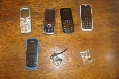Мобільні телефони різних марок у кількості: 5 шт., та розібрані зарядні пристрої у кількості: 2 шт