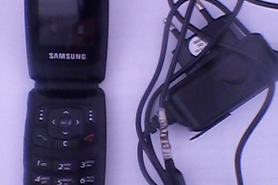 Мобільний телефон "Samsung" з зарядним пристроєм до мобільного телефону "Samsung"