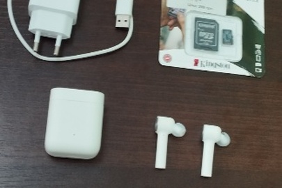 Конфісковане майно за рішенням суду: полімерний пакет із зарядним пристроєм білого кольору, USB-кабелем, боксом з двома безпровідними навушниками, флеш-картою «Kingston micro SD 64 Gb», нове