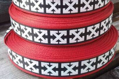Стрічка текстильна-тасьма червоного кольору, шириною 3 см. з візерунком у вигляді хрестовини з стрілками, у кількості 39 рулонів