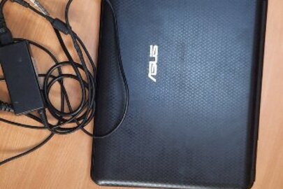 Ноутбук "ASUS" номер 15GON389320 в корпусі сірого кольору із зарядним пристроєм
