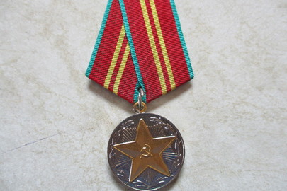 Медаль з металу білого кольору, на передній поверхні має зображення п’ятикутної зірки з металу жовтого кольору, зі зворотнього боку має надпис «За 15 лет безупречной службы», без нагородного посвідчення