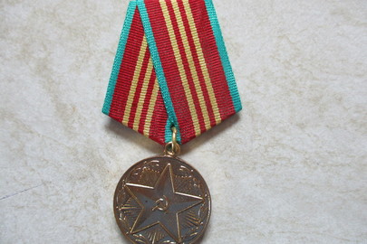 Медаль з металу жовтого кольору, на передній поверхні має зображення п’ятикутної зірки («За 10 лет безупречной службы»)