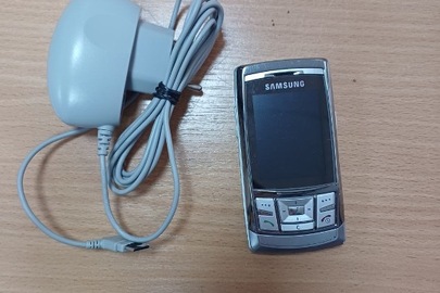 Конфісковане майно за рішенням суду: мобільний телефон "SAMSUNG D-840", IMEI 359680/00/619802/8 та зарядний пристрій до телефону "SAMSUNG", сріблястого кольору, б/в