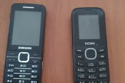 Мобільний телефон «Nomi» чорного кольору та мобільний телефон «Samsung» чорного кольору