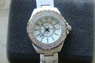 Годинник жіночий з механічною індикацією, з написом на білому циферблаті «Chanel», вироблений з металу білого кольору, з розсипами камінців білого кольору по колу корпусу