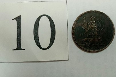 Монета з металу мідного кольору, аверс-напис "5 копеек 1723", реверс малюнок чоловіка в обладунках з твариною, гурт рифлений затертий